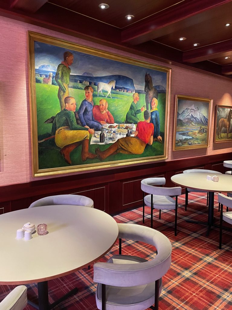 Breakfast room of Hotel Holt with large Icelandic painting of people on wall.